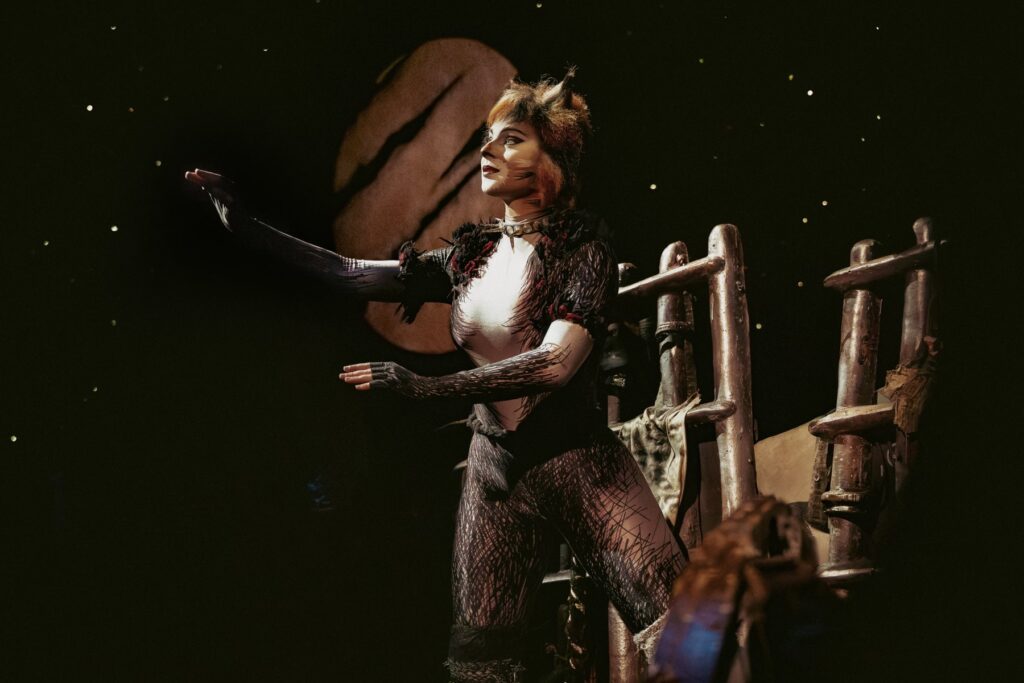 Jemima gazing up at the moon in Cats the Musical