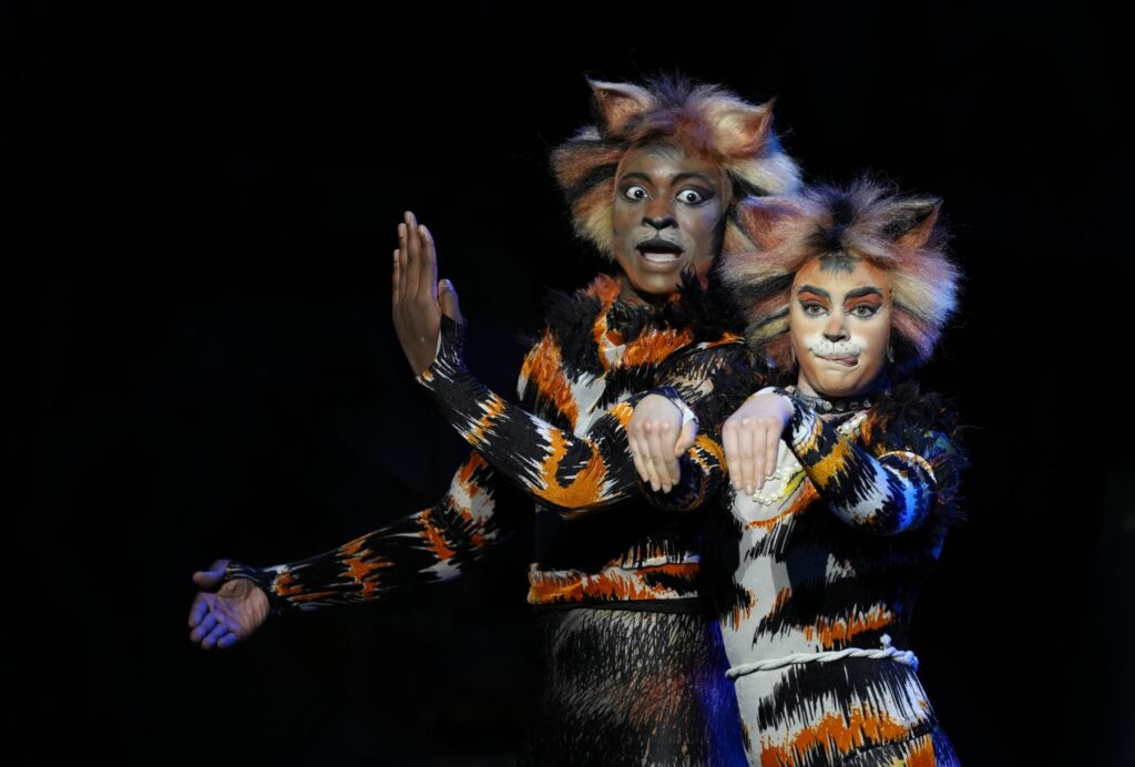 Mungojerrie and Rumpleteazer in matching orange and black patchwork costumes in Cats the Musical