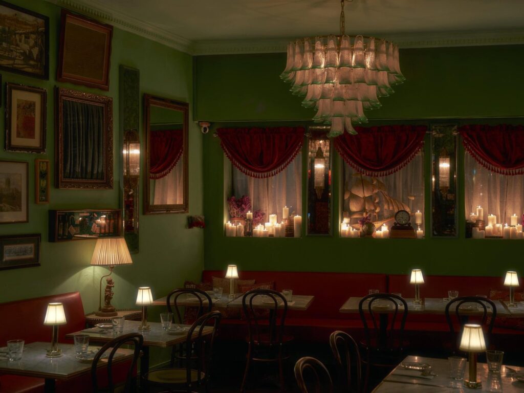 Candlelit dining room with a chandelier and velvet drapes at Marcy's in Duxton