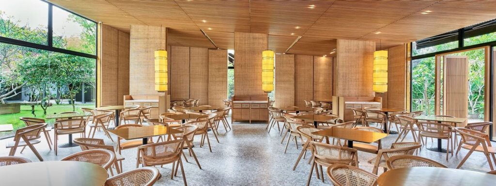 Min Jiang at Dempsey dining room with full-length windows onto greenery