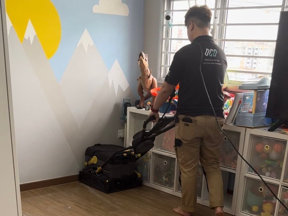 OCD cleaner using a vacuum in a newly renovated HDB room