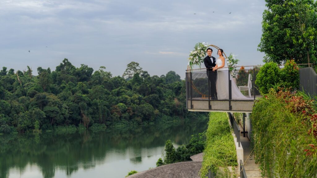 Couple at a rooftop wedding arch overlooking the lake at Mandai Rainforest Resort by Banyan Tree, one of the unique wedding venues in Singapore